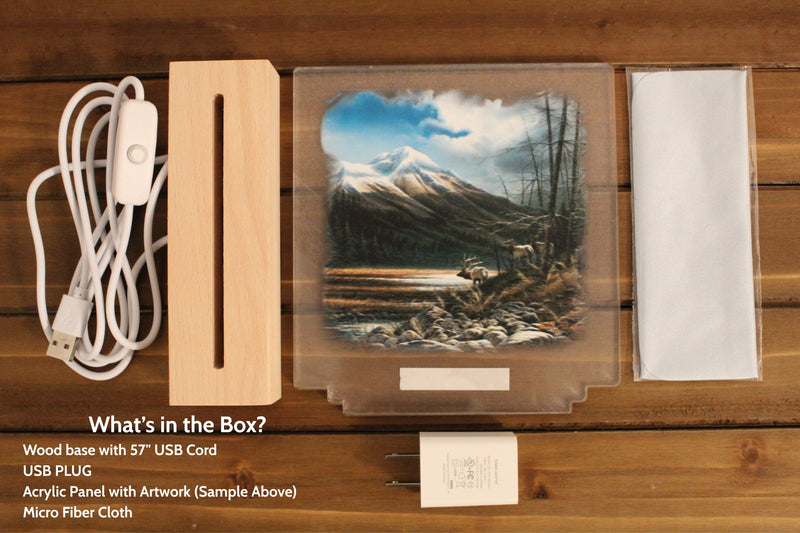 Wooden base with USB cord, acrylic panel with artwork, USB plug and microfiber cloth on a wooden surface.