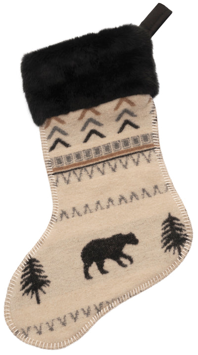 Christmas stocking with black fur trim, bear, and tree patterns on a beige background