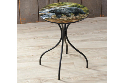 Small round table with a bear design on the top, placed on a wooden floor.