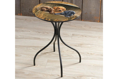 Metal round side table featuring three lab puppies by Rosemary Millete. The table is on a wooden floor.