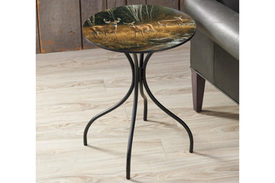 Round metal side table featuring a deer design top sitting on a wood floor.