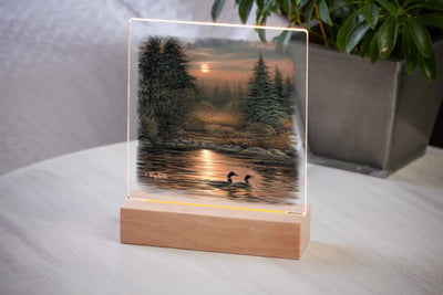 Acrylic tabletop night light featuring two loons on a high mountain lake at sunset with wood base.